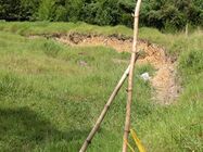 Reptación del terreno en lote vecino inmediatamente abajo del de casa 155 (familia García - Montero) por los mismos rieles (carrera 19 sur), causada por los movimientos de tierra requeridos para la urbanización Zanzíbar, ca. 60 m abajo de talud inferior. Foto L. C. García Lozano 20.07.2005